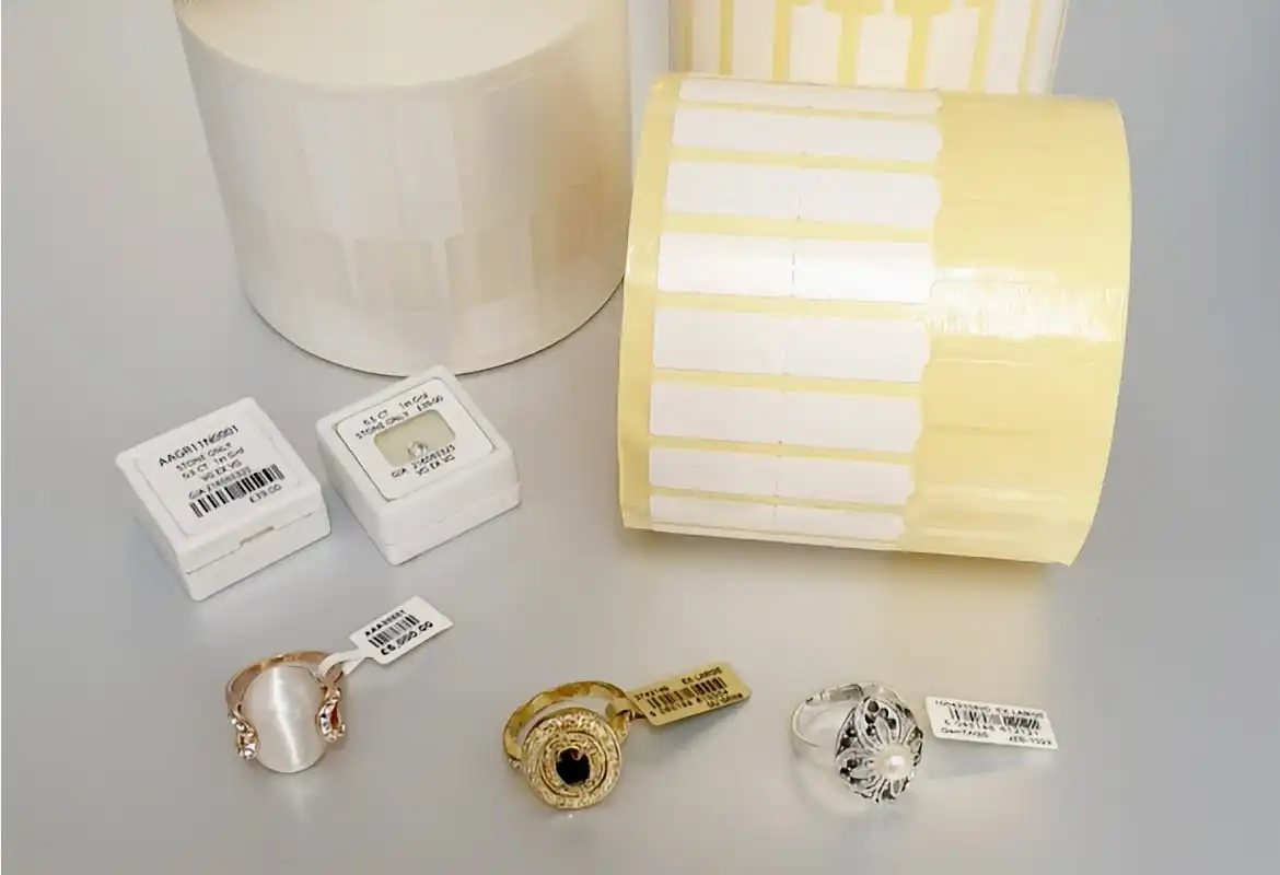 <p>GemTAGS label rolls with tagged rings and labelled jewellery boxes on a silver surface</p>
