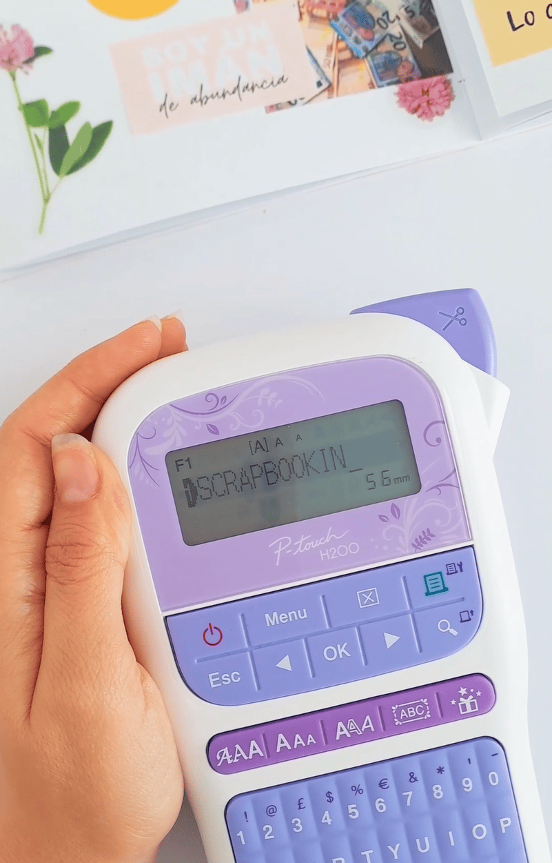 <p>Brother p-touch craft label printer device being used to create a scrapbook</p>