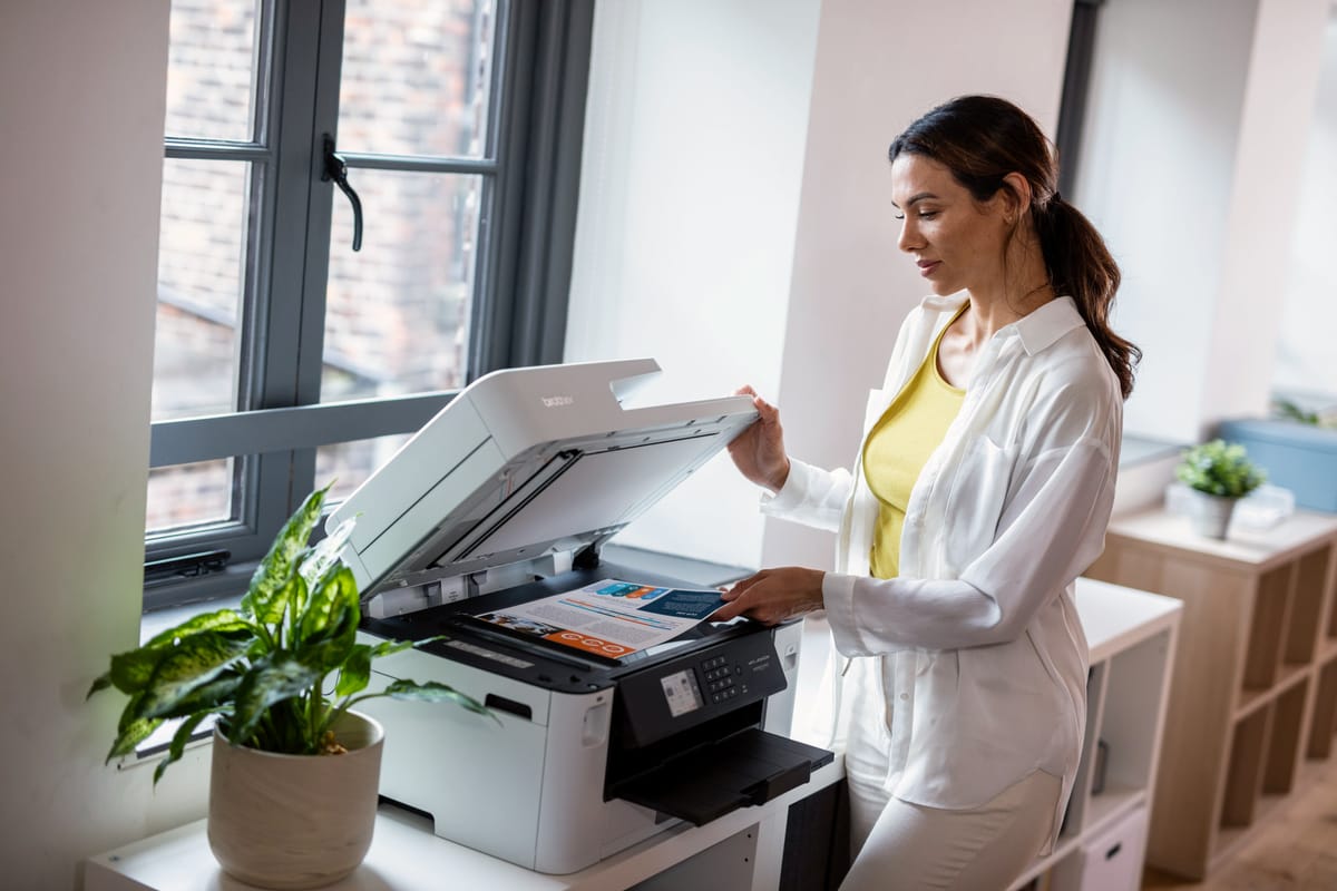 <p>A lady using a Brother MFC-J5340DWE multifunction inkjet printer to scan a colour document in an SMB environment</p>
