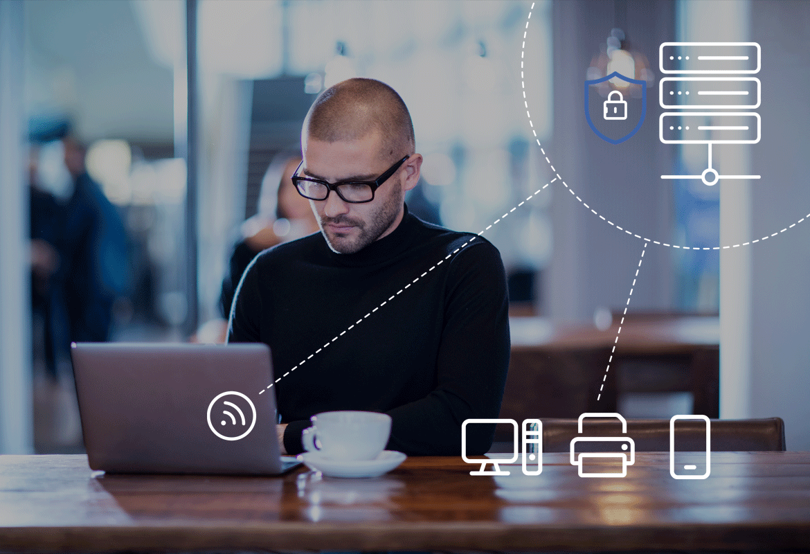 <p>A man sat in an office working on his laptop</p>